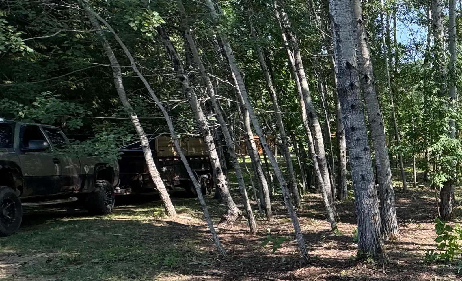 The Just Junk It pickup and dump trailer parked at a job site in Grand Rapids, Minnesota.